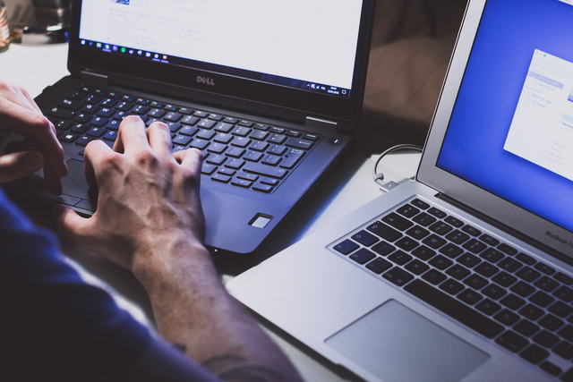 Someone working on two different laptops