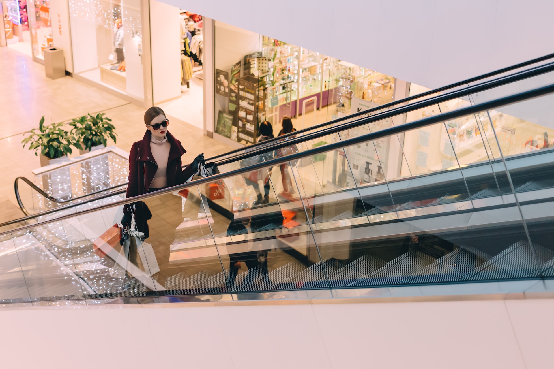 woman on an escalator in a shopping mall or retail environment  