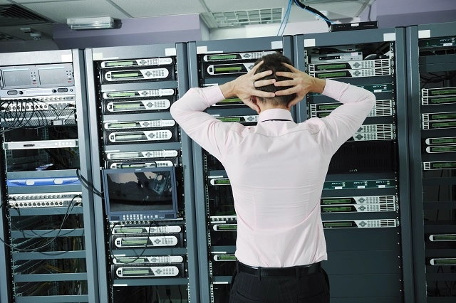 Frustrated IT worker in a server room dealing with an outage