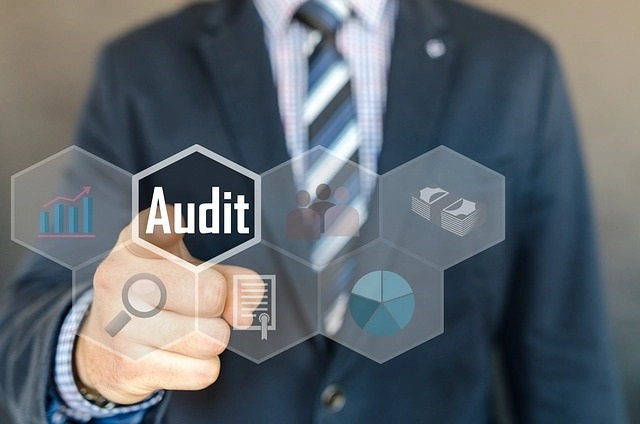 Person in a suit pushing an audit icon