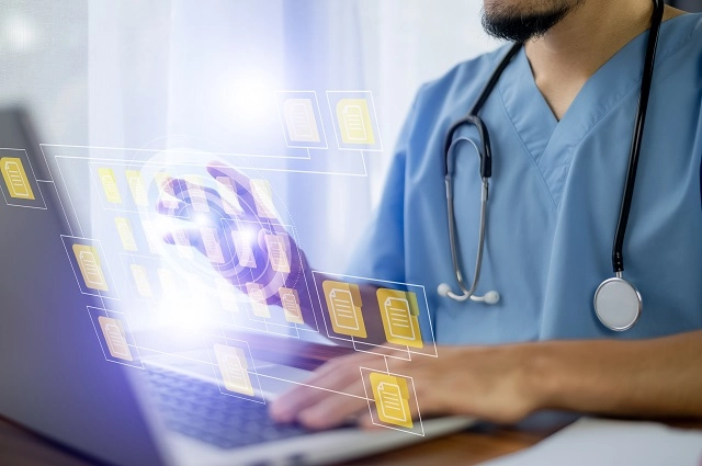 Healthcare provider using a laptop and accessing files from the cloud