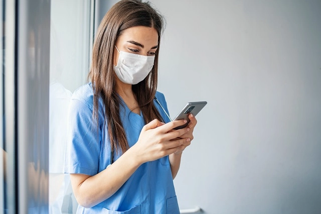 Healthcare provider using Slack or another messaging app on a smartphone
